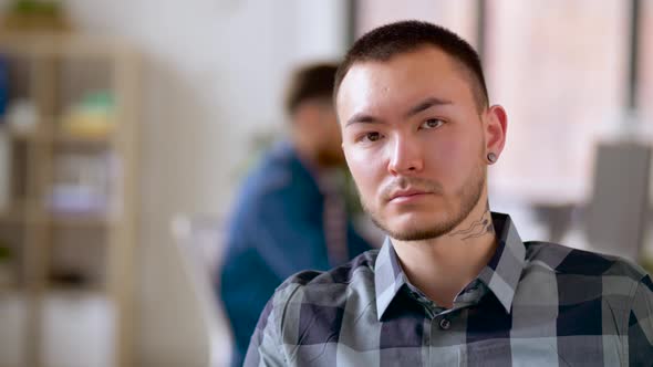 Asian Man with Tattoo and Ear Tunnel at Office  alt
