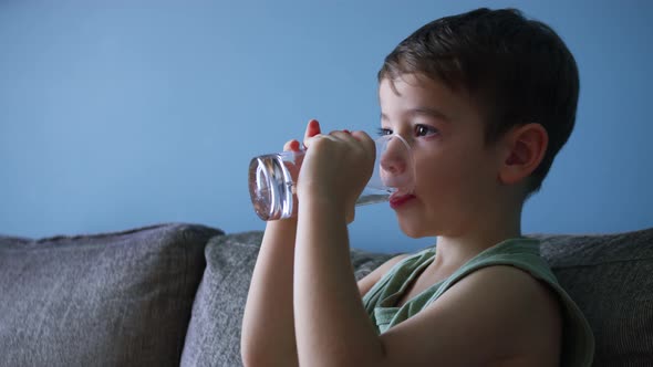 Cute Little Baby Boy Drinking a Glass of Water in Home alt