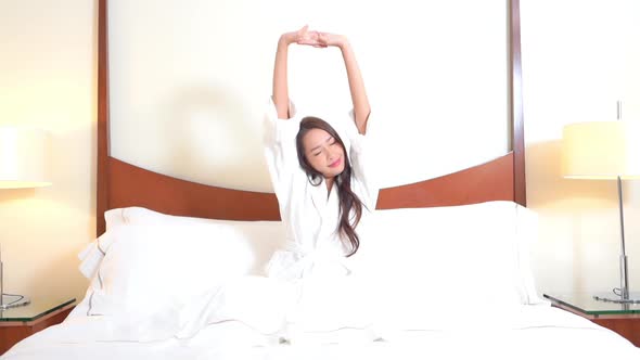 Asian woman relax on bed in bedroom interior alt