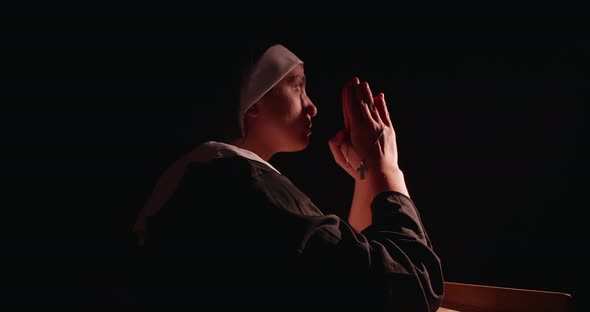 Young Nun Praying In The Dark