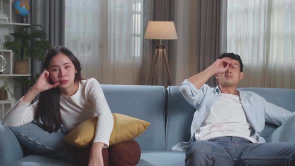 Young Asian Couple Are Watching Tv At Home With Sad Faces. Human Emotions And Television Concept alt