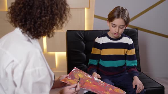 Psychologist and Child Talking About His Painting alt