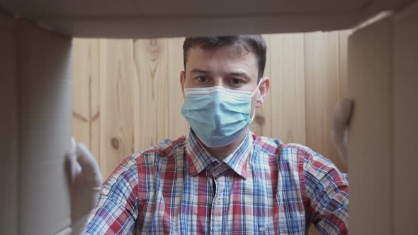 A man opens a home delivery box. Food delivery during quarantine alt