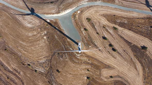 Boundless Fields with Shrubs and Road Against Wind Turbines