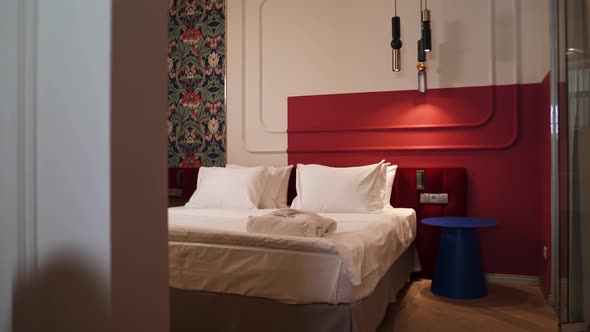 Large Double Bed in an Elite Hotel Against the Background of a Red Wall