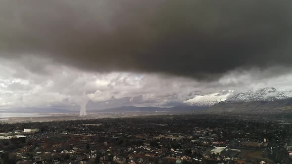 Flying over town with dark gloomy storm clouds hanging low alt