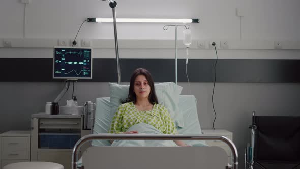 Patient Wearing with Nasal Oxygen Tube Looking Into Camera Sitting in Bed alt