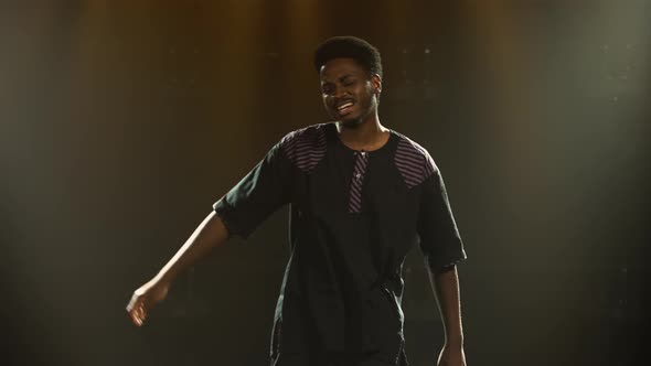 African American Young Man in National Ethnic Costume Dances with Pleasure and Sings a Song alt