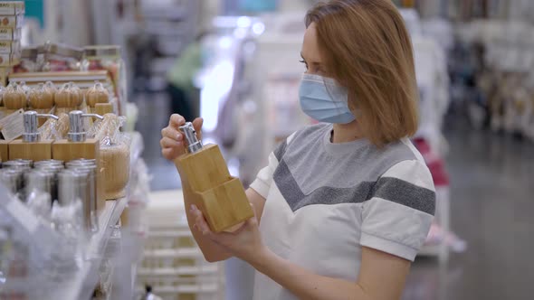 A Beautiful Woman in a Medical Mask Came Shopping. A Hardware Store, the Girl Chooses Accessories alt