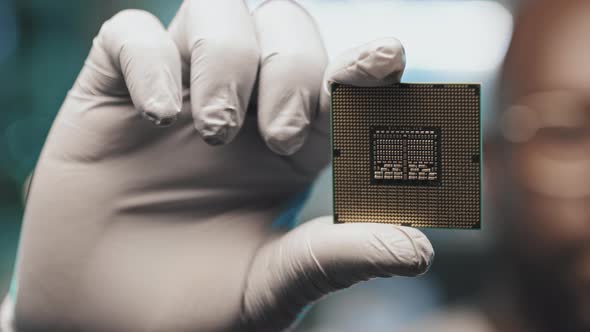 Lab Engineer in Gloves Holding Microprocessor alt