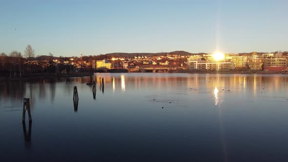 Vibrant sunset above Hjellevannet lake in Telemark canal Skien Norway - Aerial flying closeto water alt