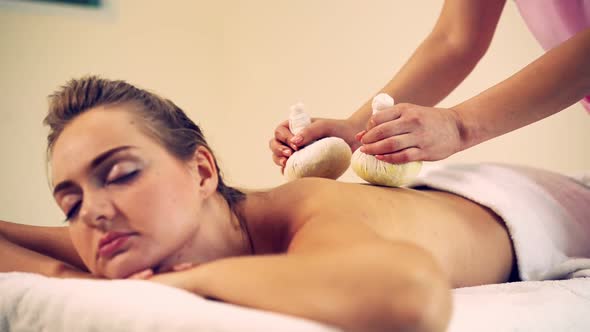 Massage Therapist Using Herbal Compress on Woman alt