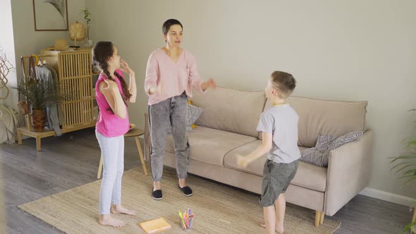 Mother with Little Son and Teenage Daughter Plays Funny Game