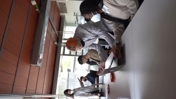 Company of multiethnic colleagues in masks working together in office alt