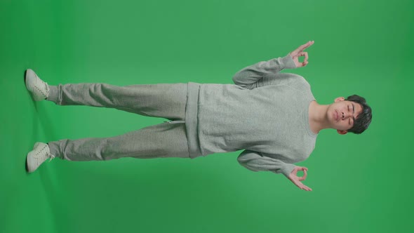 Full Body Of Asian Man Concentrate In Front Of Green Screen Background alt