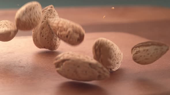 Almonds falling onto wooden surface in super slow motion.  Shot on Phantom Flex 4K high speed camera