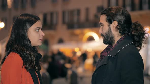 Young Couple Talking in Crowded Street at Night alt