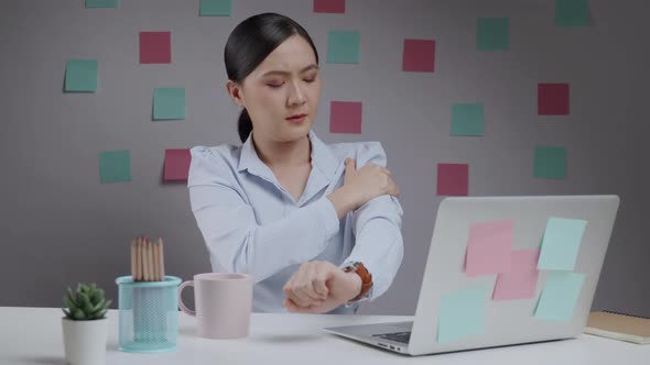 Asian woman working on a laptop was sick with body pain sitting