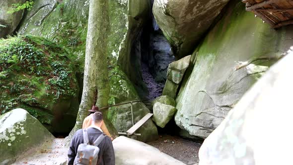 Couple Hikers Walking By Trail Into Cave alt
