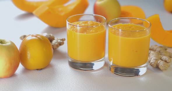 Pumpkin and Ginger Smoothie is Poured Into Glasses Against a Background of Fresh Vegetables and alt