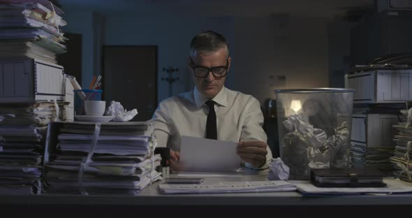 Businessman throwing paperwork in the trash can