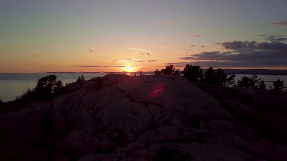 Inukshuk on Peak of Rocky Pine Tree Island at Sunset, Drone Aerial Wide Orbit Pan. Blue Lake, Colorf alt
