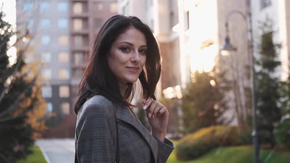 An Attractive Girl of European Appearance Looks at the Camera on the Street alt