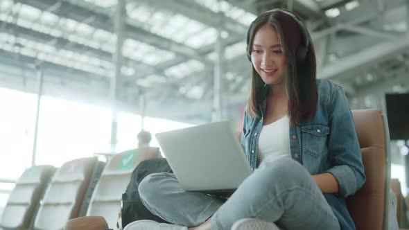 travel vacation concept,asian female woman wear headphone hand use laptop