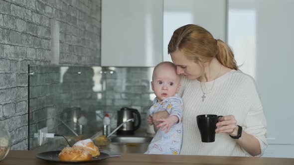 mom with son in her arms in the kitchen