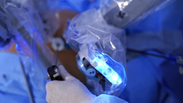 Surgical procedure. Doctor's hand in sterile glove during the robotic surgery. alt