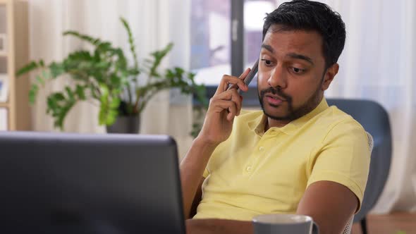 Man with Laptop Calling on Phone at Home Office alt