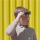 Boy Raises His Sunglasses and Looks Suspiciously Near Bright Yellow Ribbed Wall - VideoHive Item for Sale