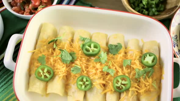 Chicken enchiladas with cheddar cheese and sauce. alt