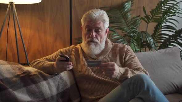 Pensioner Paying Online Using Credit Card and Application From Smartphone. Elderly Person Using alt