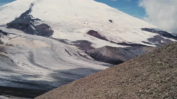 Aerial Flight of a Man Running Down in a Big Mountains