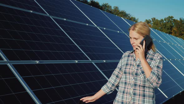 Woman with Smartphone Goes Aquarius Solar Panels at Home Solar Power Plant alt