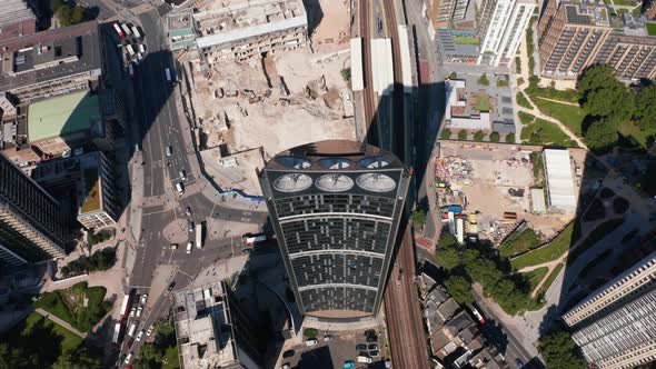 Aerial Birds Eye Overhead Top Down View of Strata Apartment Building with Wind Turbines in alt
