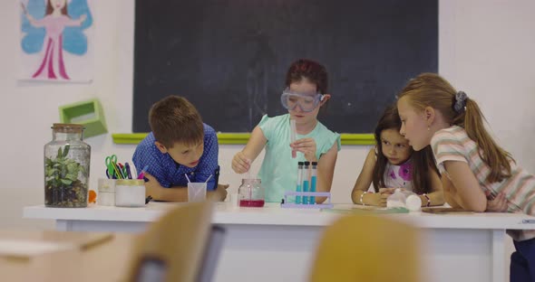 Elementary School Science Classroom Enthusiastic Teacher Explains Chemistry to Diverse Group of alt