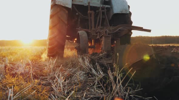 Rear View of an Old Gray Tractor with a Harrow alt