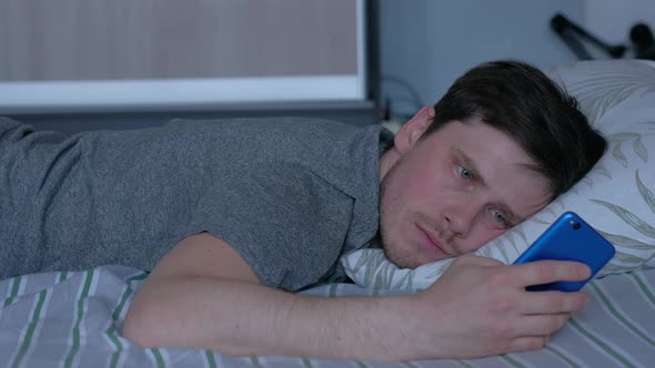 a Man Experiences a Feeling of Loneliness Lying on the Bed alt