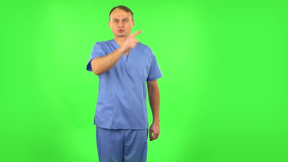 Medical Man Threatens with a Finger and Waves Her Head Negatively. Green Screen alt