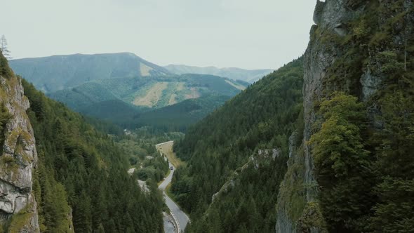 Aerial View of a Mountain Road in a Beautiful Deep Gorge. Cars Move on a Mountain Road alt
