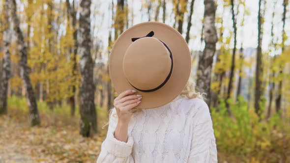 Portrait of Smiling Happy Cheerful Woman with Brown Hat in Autumn Park alt