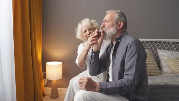 Senior Man Using Asthma Inhaler for Relief an Attack at Home for Preventing Attack Wife Support