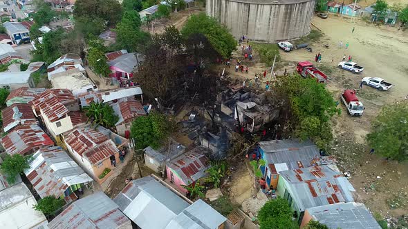 Aerial view around firefighters and people at a burnt building fire, in the slums of Mexico city, Ce alt