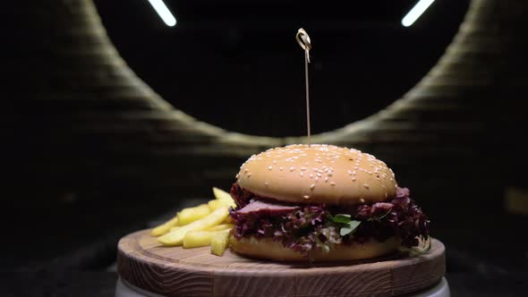 Appetizing Beef Burger Rotating on the Wooden Desk