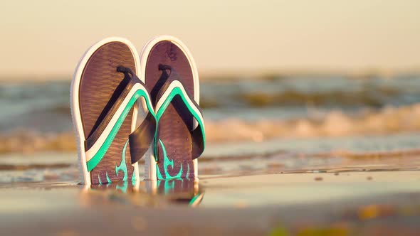Flip Flops Illuminated By the Setting Sun at the Sea alt