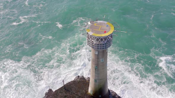Lighthouse on a Rock in the Ocean with Crashing Waves and a Helipad alt
