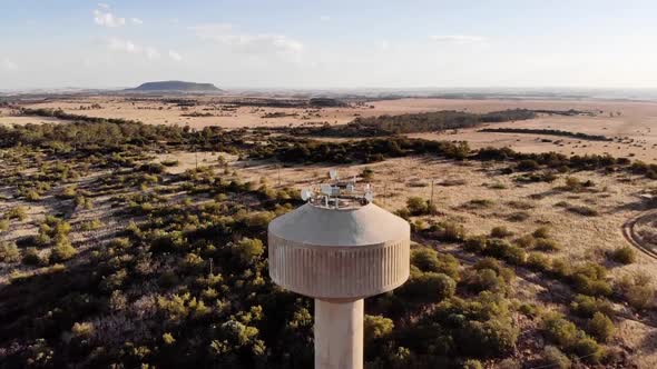 DRONE Drop Down Shot of a Broadcast Tower in a Rural Area on a Sunny Day alt