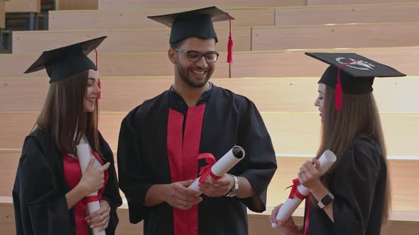 Graduates in Robes Holding Certificates, Talking. alt
